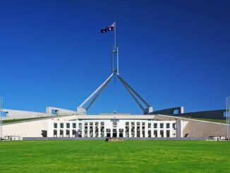 Parliament House with Australian flag, sunny day.