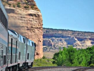 Train traveling through scenic desert landscape.
