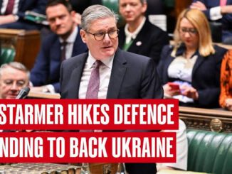 Politician speaking in parliamentary session, headline displayed.