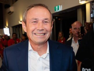 Smiling man in a suit at event.