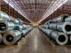Steel coils stacked in a warehouse interior.