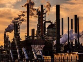 Industrial factory with smokestacks at sunset.