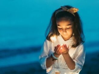 Girl holding light by the beach.