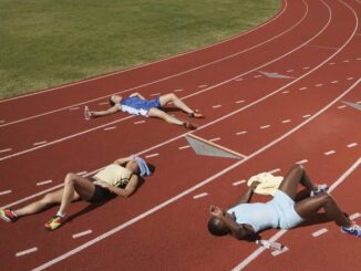Runners lying exhausted on a track.