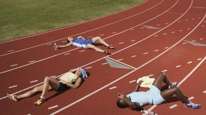Runners lying exhausted on a track. Runners lying exhausted on a track.