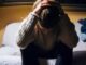 Person sitting with head in hands, distressed.