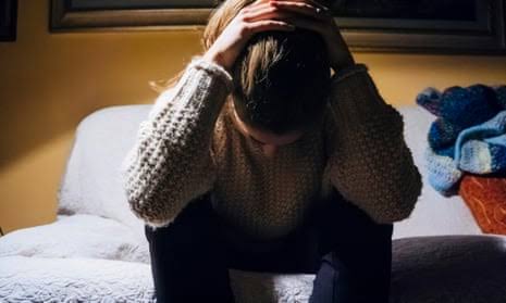 Person sitting with head in hands, distressed.
