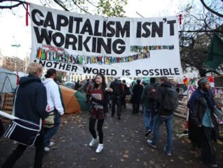 Protesters under "Capitalism Isn't Working" banner.