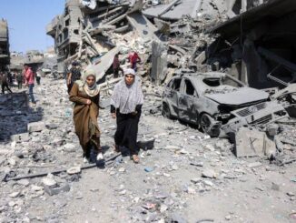 Women walking through rubble and destruction.