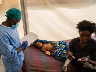 Healthcare worker attending to child and mother.
