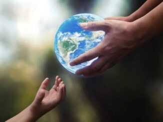 Hands passing a globe, symbolizing unity.