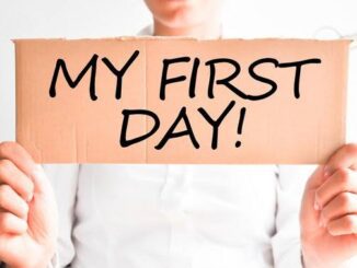 Person holding "My First Day" sign.
