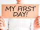 Person holding "My First Day" sign.