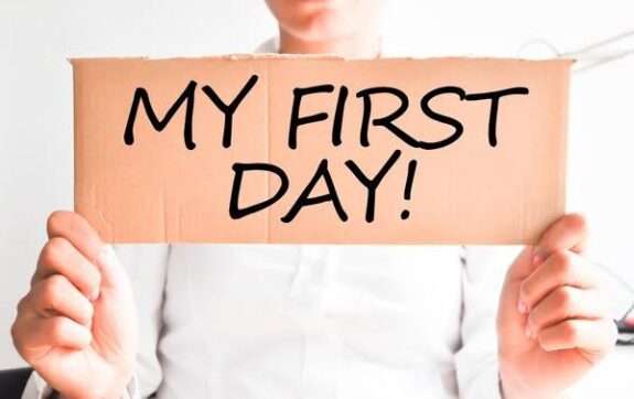Person holding "My First Day" sign.