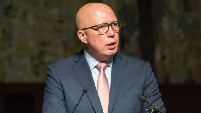 Man speaking at a podium, wearing glasses.