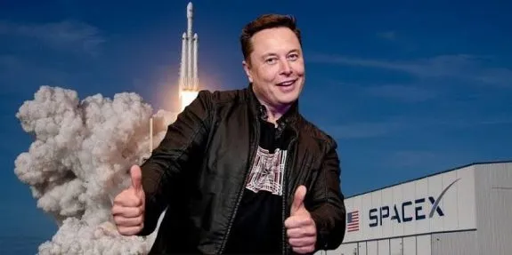 Man giving thumbs up near rocket launch.