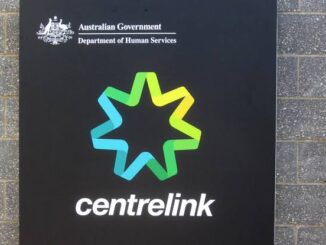 Centrelink sign on brick wall background.