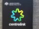 Centrelink sign on brick wall background.