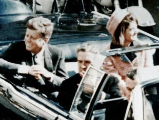 People in a convertible car during parade.