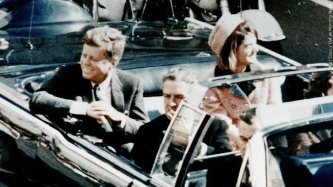 People in a convertible car during parade.