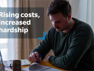 Man writing at table, text: "Rising costs.