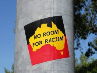 Sticker reading "No Room for Racism" on pole.