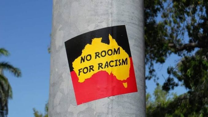 Sticker reading "No Room for Racism" on pole. Sticker reading "No Room for Racism" on pole.