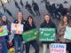 Women holding pro-nuclear energy signs outdoors.