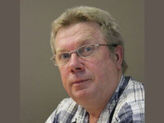 Man with glasses wearing plaid shirt.