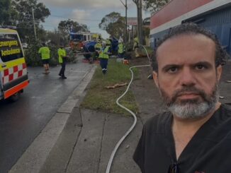 Man at emergency response scene with vehicles.