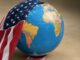 Globe partially covered by American flag.