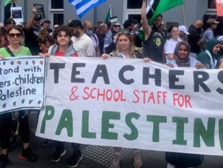 Protesters holding signs supporting Palestine teachers.