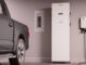 Truck charging in a garage with equipment.