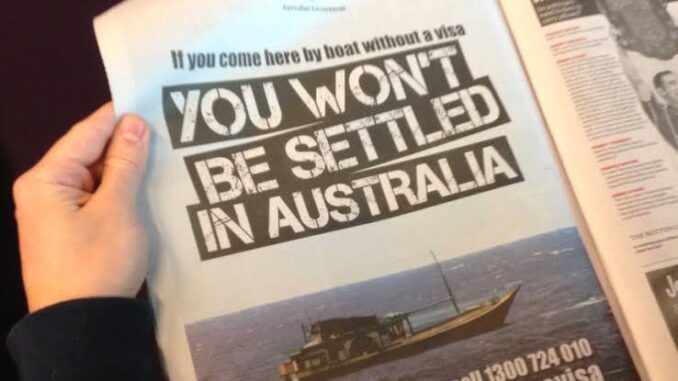 Hand holding newspaper with Australian immigration warning. Hand holding newspaper with Australian immigration warning.