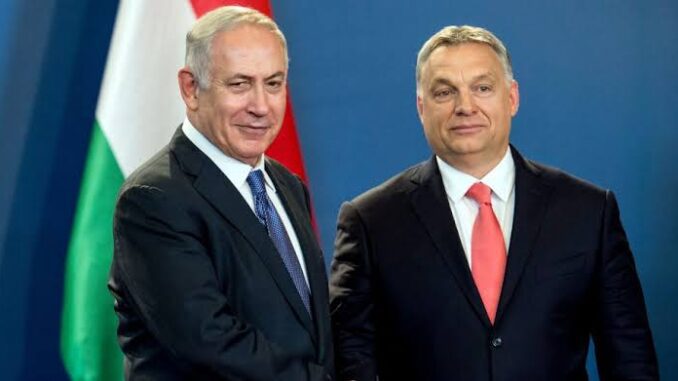 Two men shaking hands, flags in background.