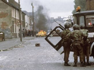 Soldiers and burning car in urban conflict.