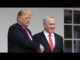 Two men shaking hands, wearing suits.