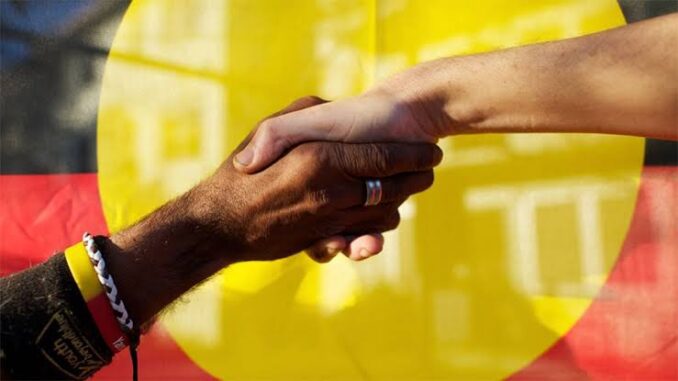 Two people shaking hands in front of a yellow background. Two people shaking hands in front of a yellow background.