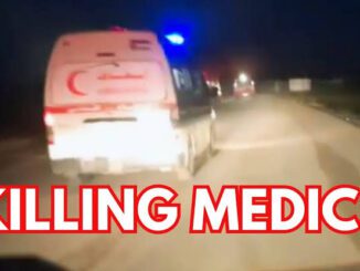 Ambulance vehicles with flashing lights on a dark road.