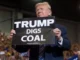 Donald Trump holding a sign that says 'Trump Digs Coal'.