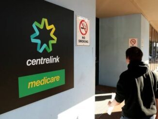 Person entering a Centrelink and Medicare office with no smoking signs visible.
