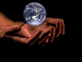 Hands gently holding a glowing Earth against a black background.