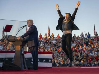 Politician speaking, person jumping enthusiastically nearby.