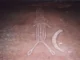 Ancient rock carving of a stylized animal figure with elongated body and limbs.