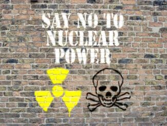 Graffiti on a brick wall saying 'SAY NO TO NUCLEAR POWER' with nuclear and skull symbols.