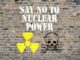 Graffiti on a brick wall saying 'SAY NO TO NUCLEAR POWER' with nuclear and skull symbols.
