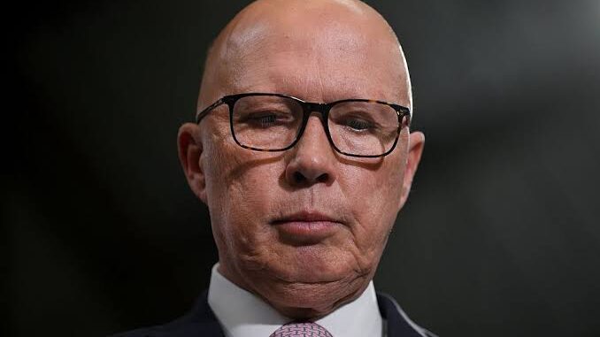 Serious bald man wearing glasses and a suit.