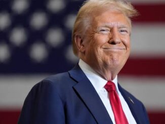 A man in a suit with an American flag backdrop.