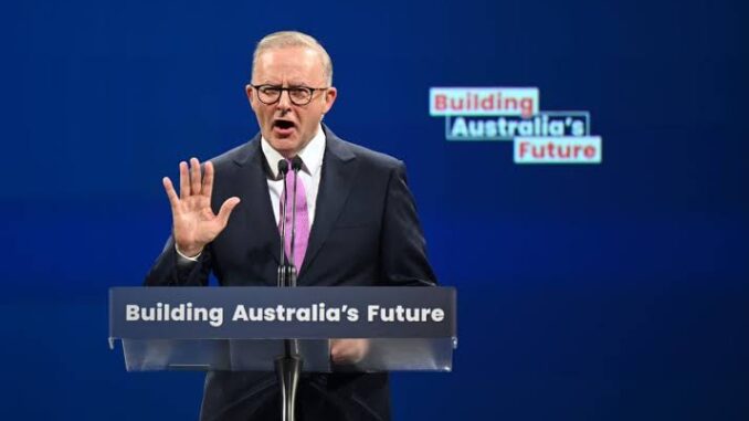 A man speaking at a podium with "Building Australia's Future" signs.