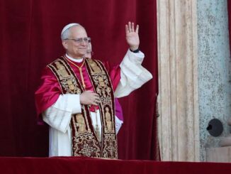 A pope in ornate robes waving from a balcony.